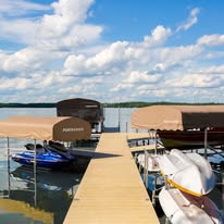 Finished dock between boats on a sunny lake